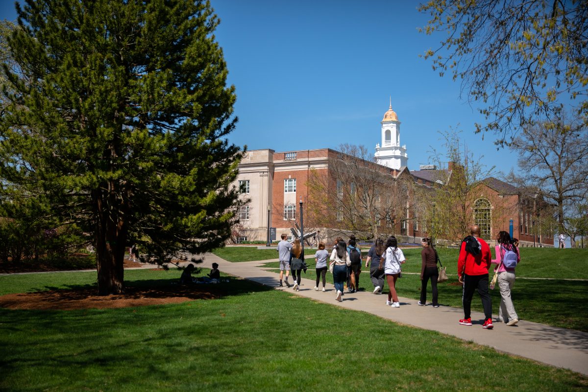 Students walking on the Storrs campus in front of the Wilber Cross building.