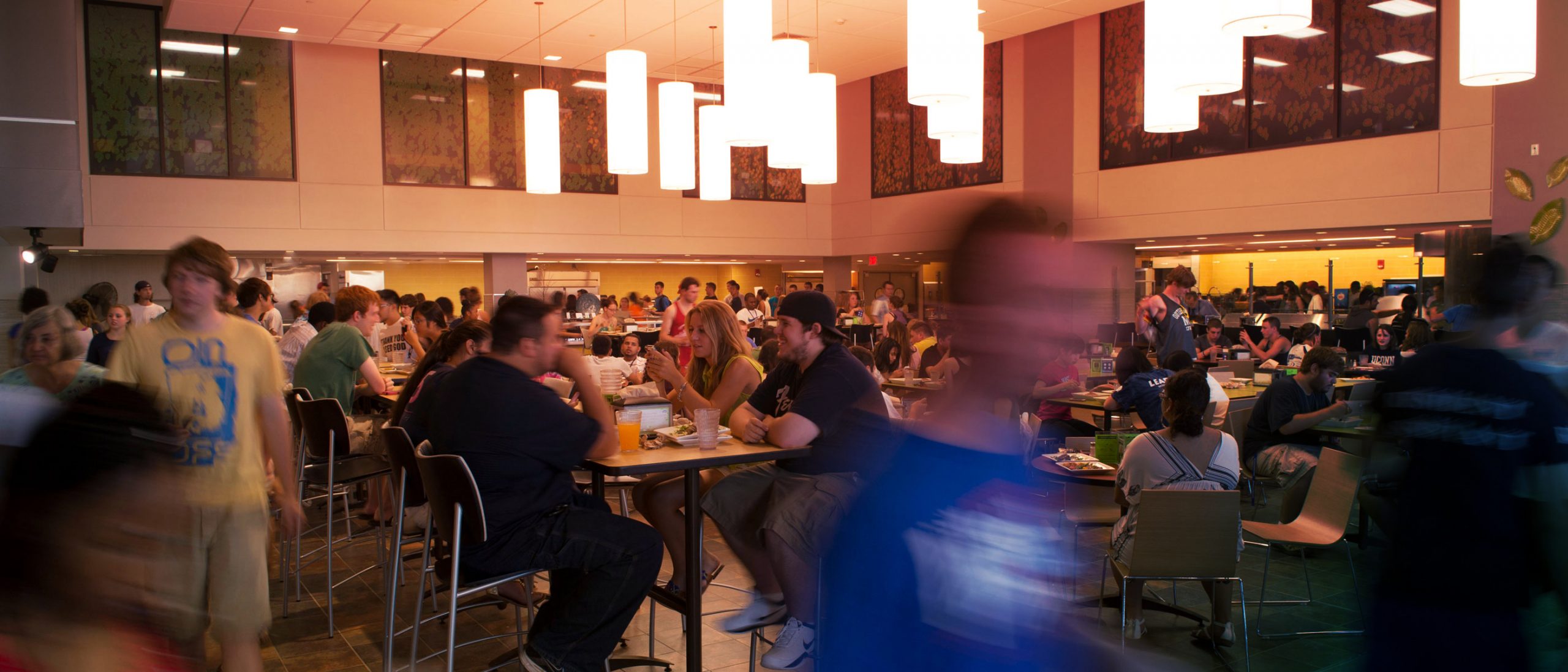 hundres of students (pre-covid) come together to eat at a dining hall on campus