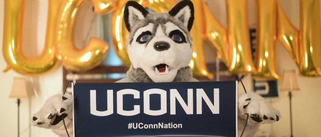 Admit Day video screenshot featuring Jonathan the Husky mascot holding a UConn sign