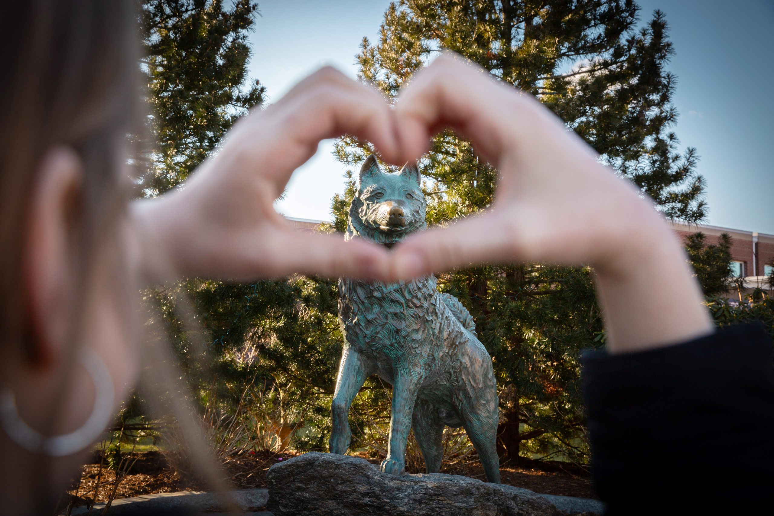 Hands in a heart shape around the Jonathan Statue for Valentine's Day.