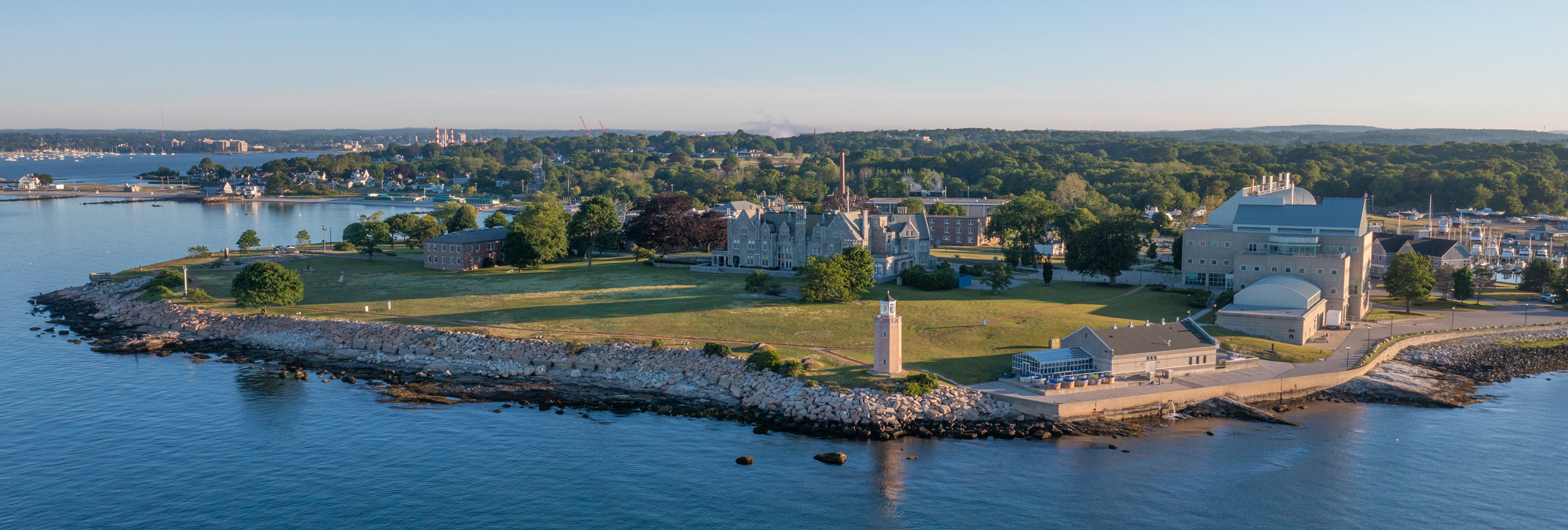 Avery point campus shot on a drone circling the coast and showcasing the lighthouse and a few surrounding buildings