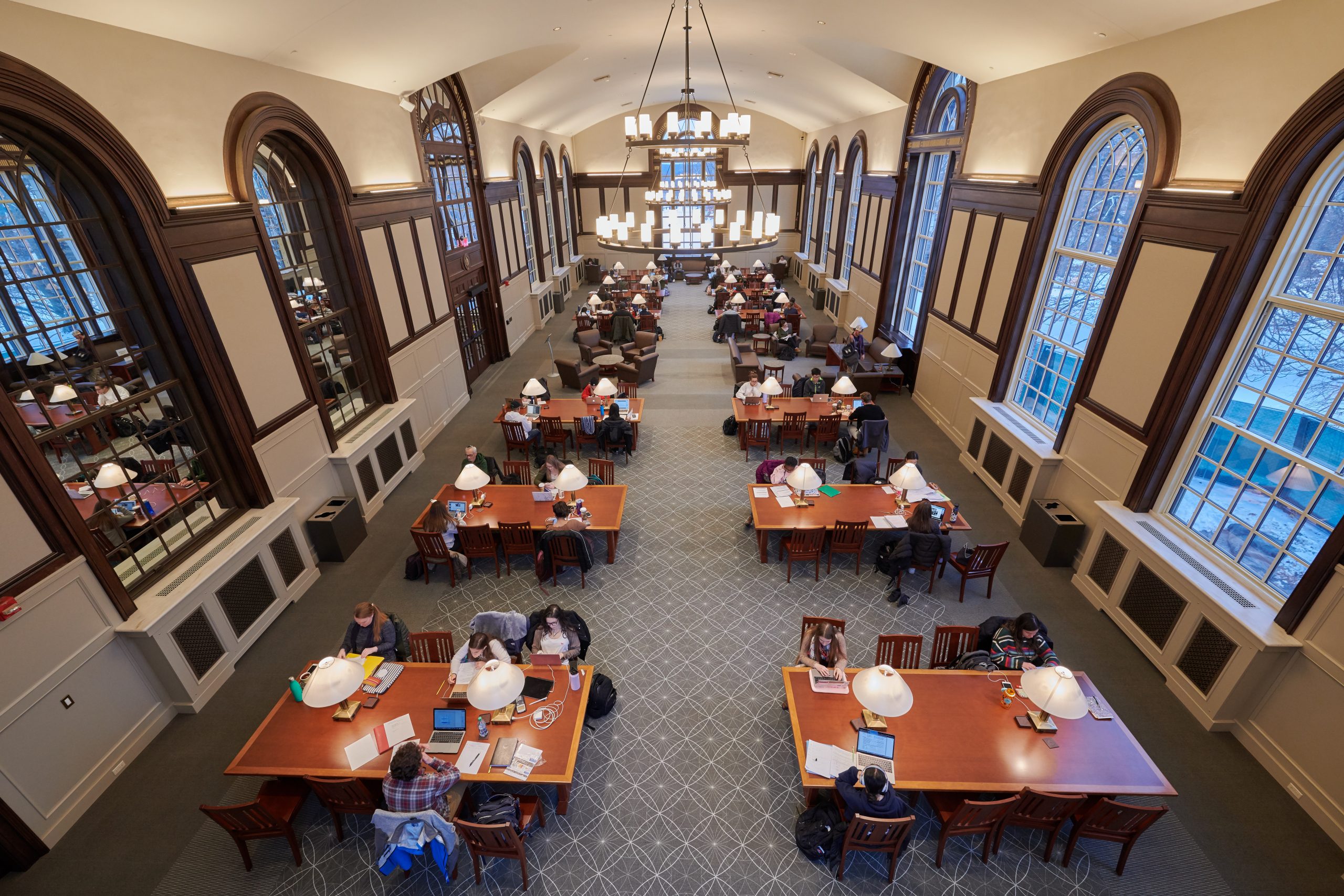 students studying in an room with tall windows